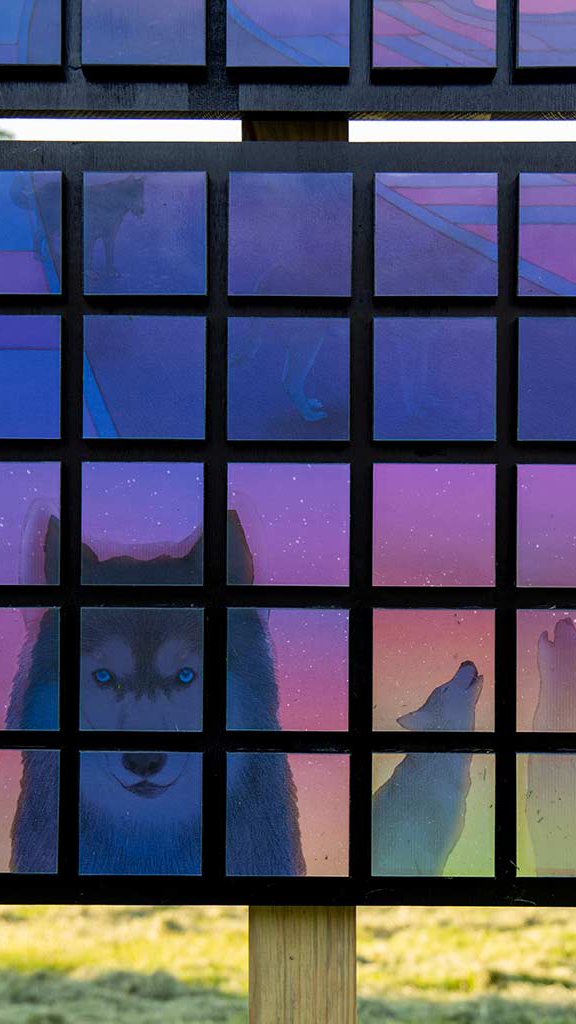 Three wolves are showing on digital panels in dark blues and purples and sunset tones
