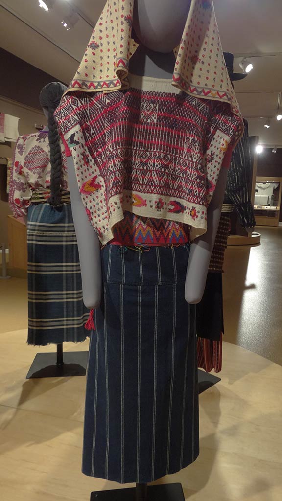yellow head cloth and red top that have similar patterns, navy blue dress