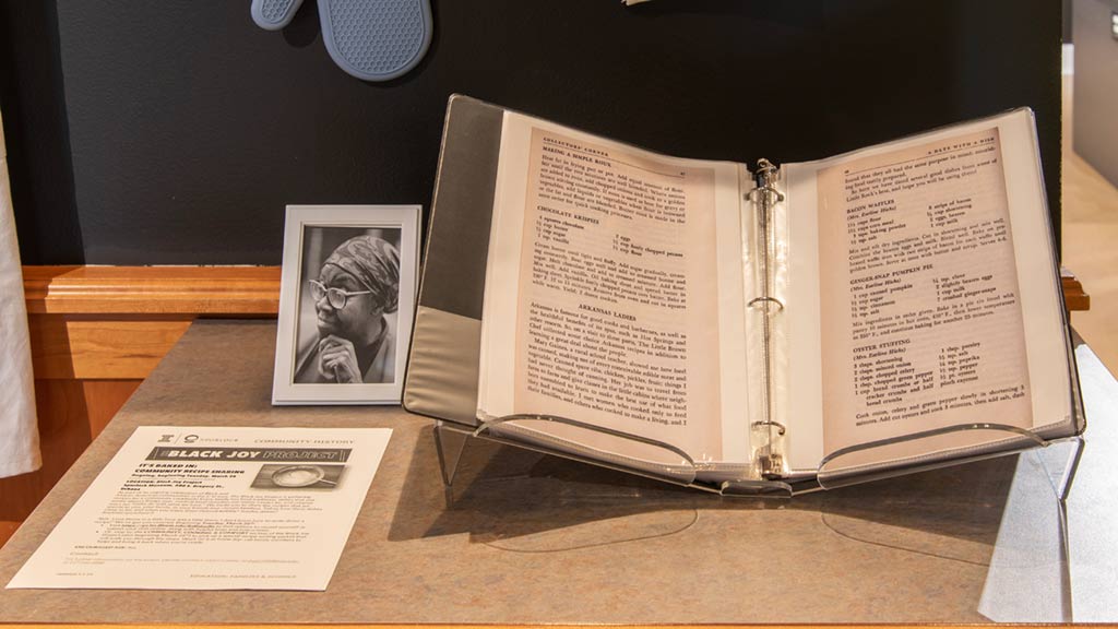 A cookbook and a black and white photograph of an elderly black woman with glasses