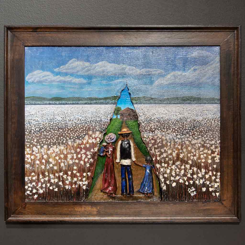 A framed painting of a black family walking towards a green field