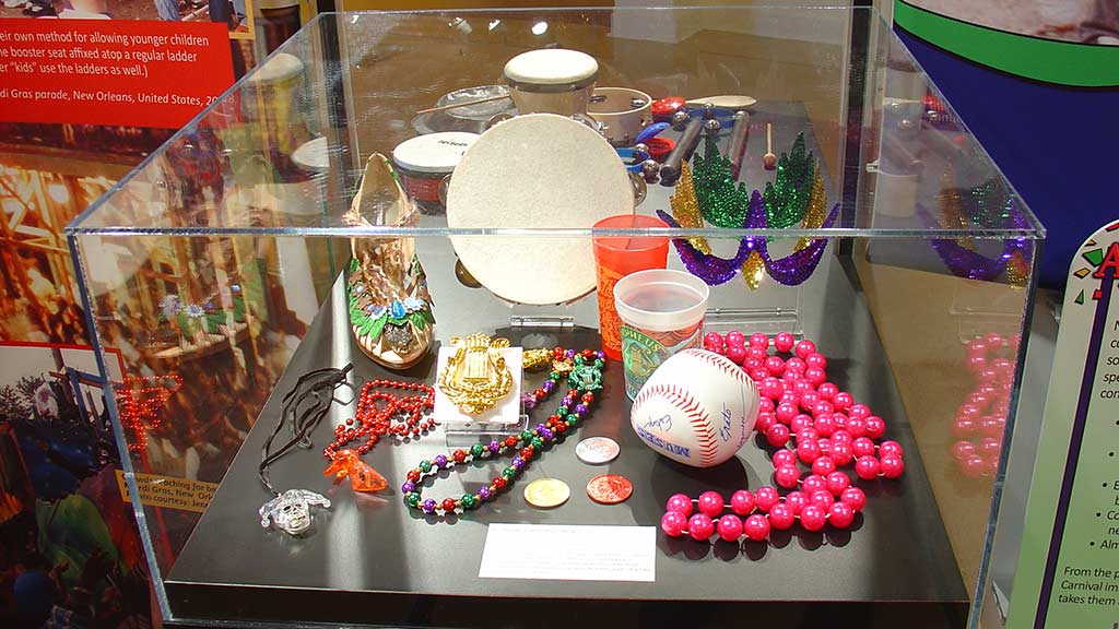colorful beads in a case with other carnival objects like themed cups, a soft ball and coins
