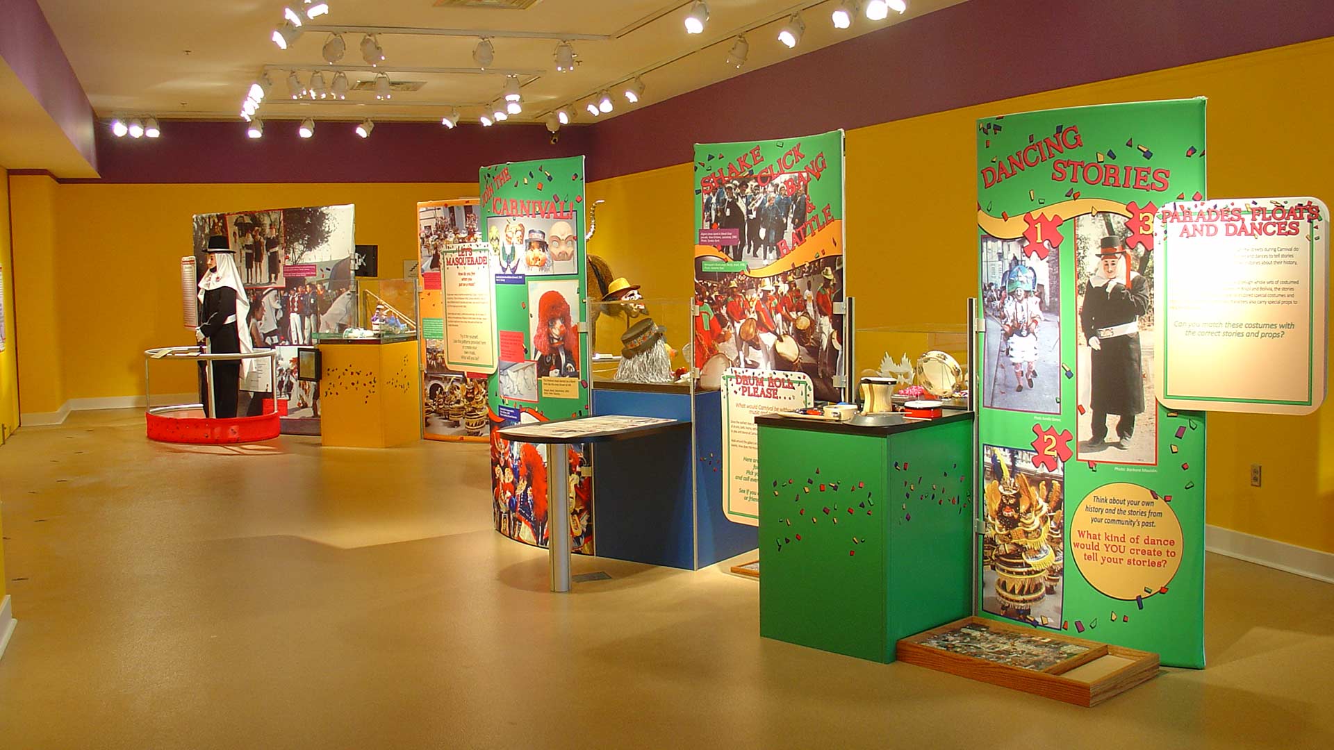 three display stands with large green posters on the side from a few aforementioned text panels and objects