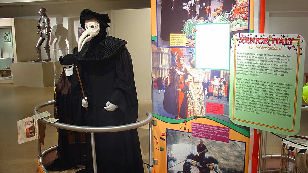 man dressed in black wearing a white mask, probably the god of death, standing next to another man in a similar outfit