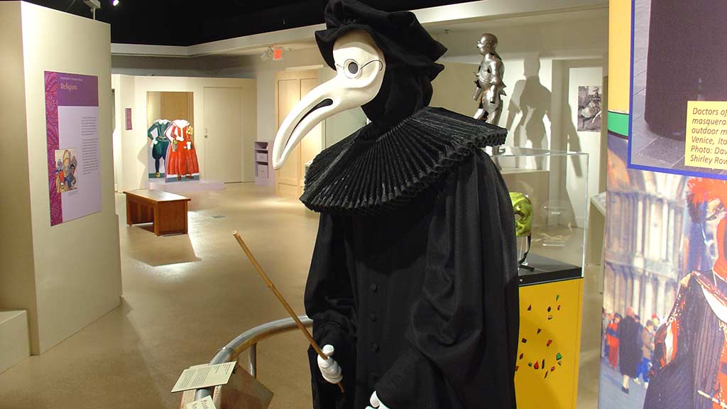 one of the men in black is wearing a mask that looks like a bird with long beak, god of death