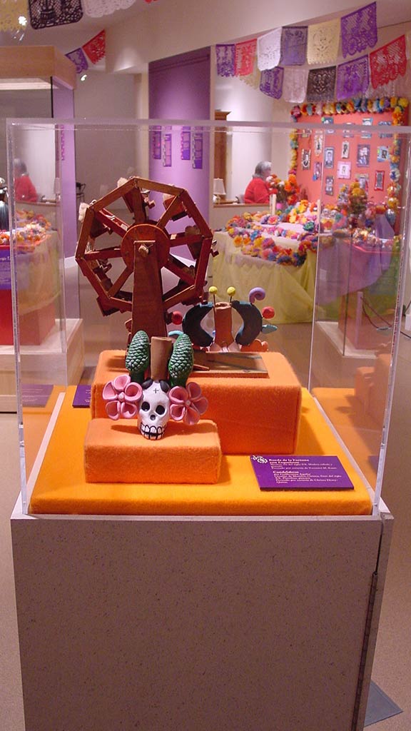 decorative skull in front of a skywheel made of wood, skeleton's headpiece to the side