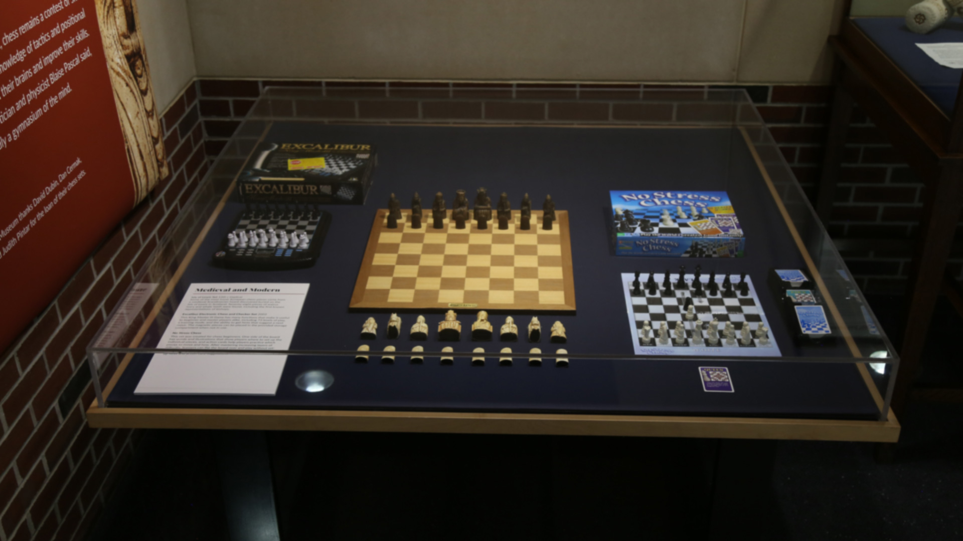 chess boxes, boards and pieces in a display case