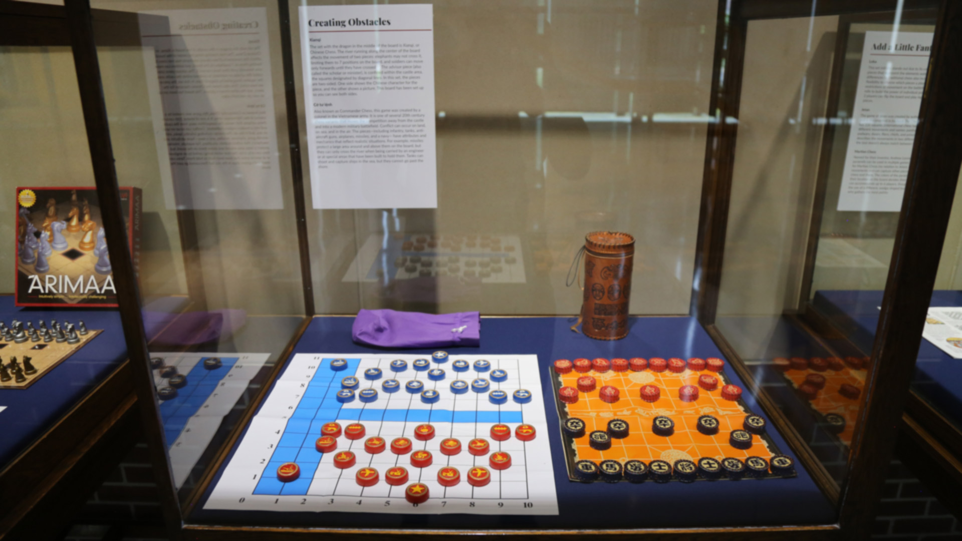 chess-like games in a display case with their boards and pieces, with the names 'loka' and 'jetan'