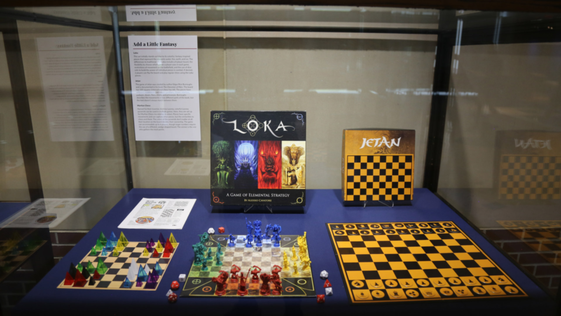 more chess-like games in a display case with their boards and pieces