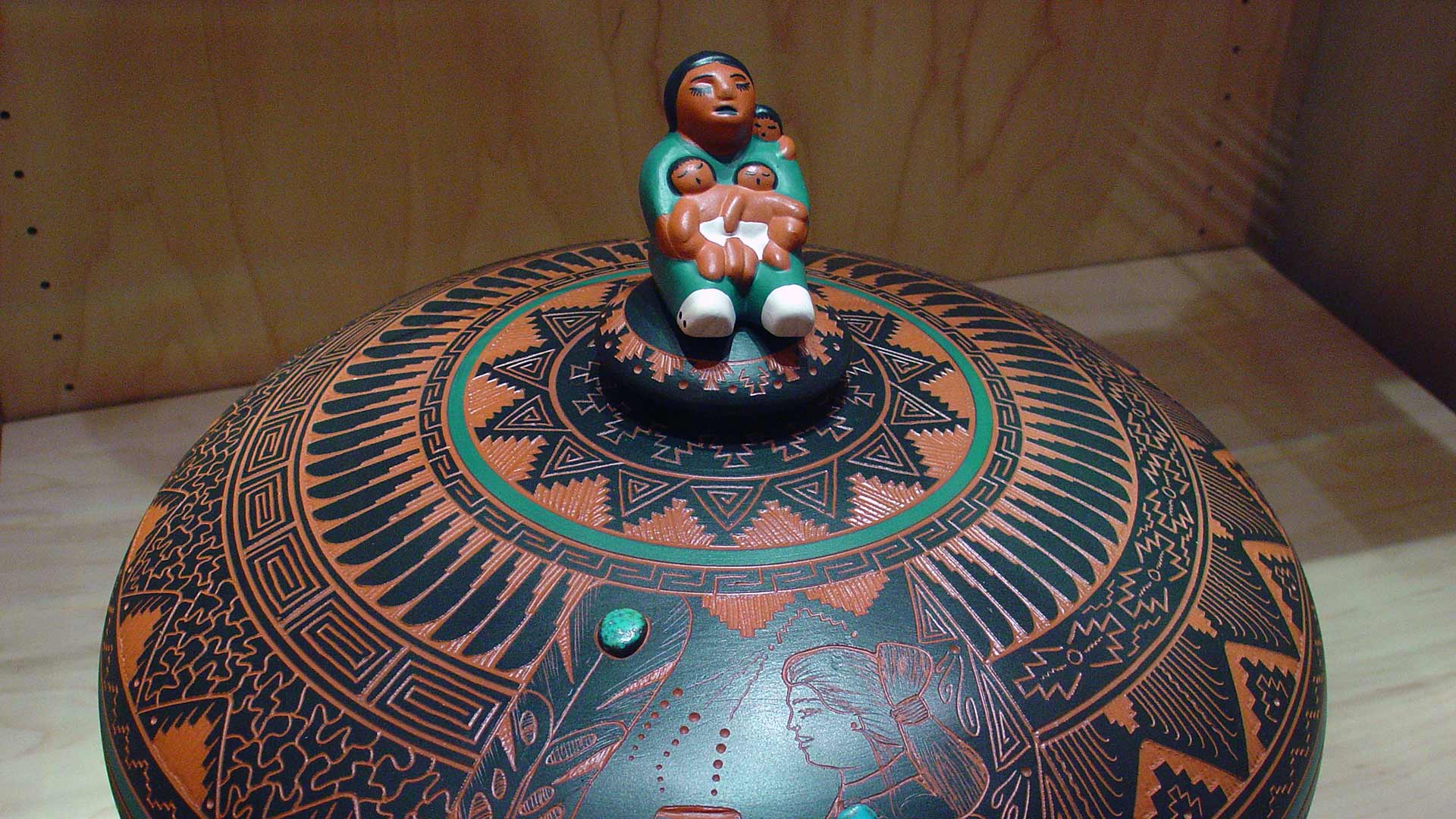 a woman holding children sitting on the top of a sphere object