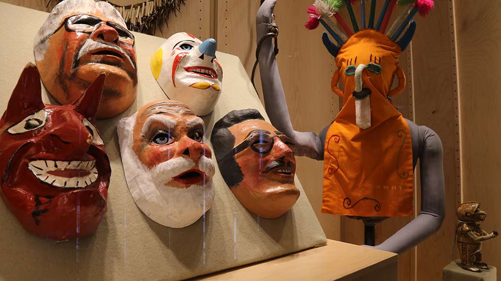 mannequin holding whip and masks view from an angle