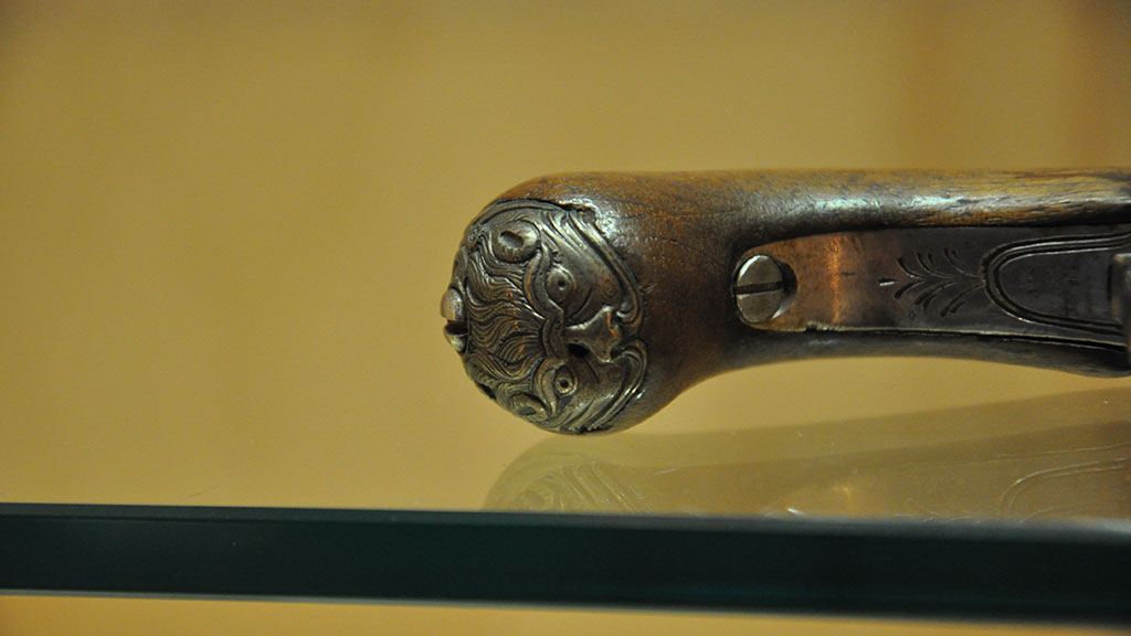 close-up of a decorated butt cup on a pistol