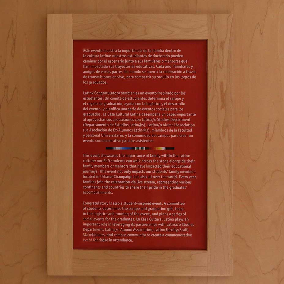 A plaque describing the importance of the Latinx Congratulatory for graduates and family in Spanish and English language