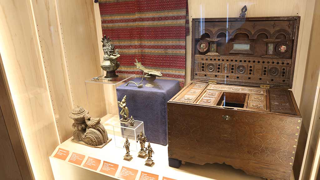 metal sculptures and a large wooden case with many small drawers alongside many other figures