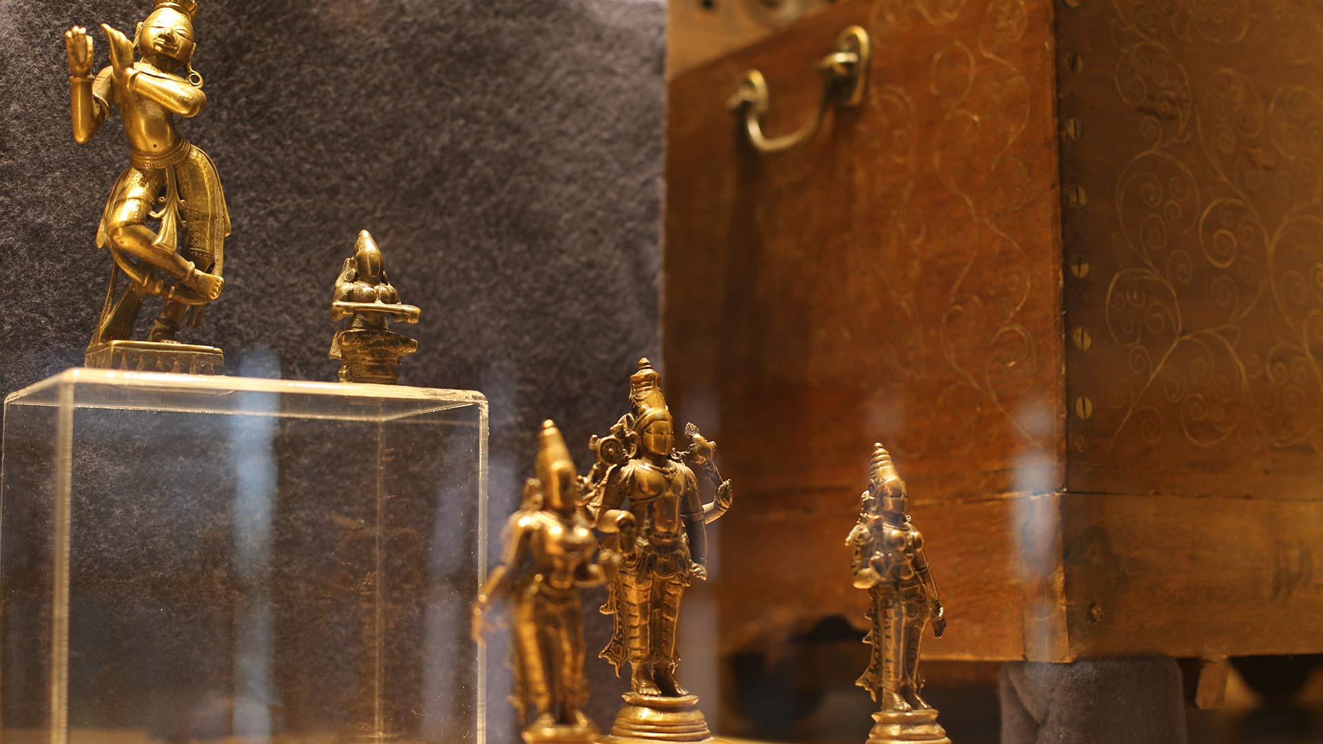 close-up of golden metal sculptures that are probablly made of bronze depicting various figures