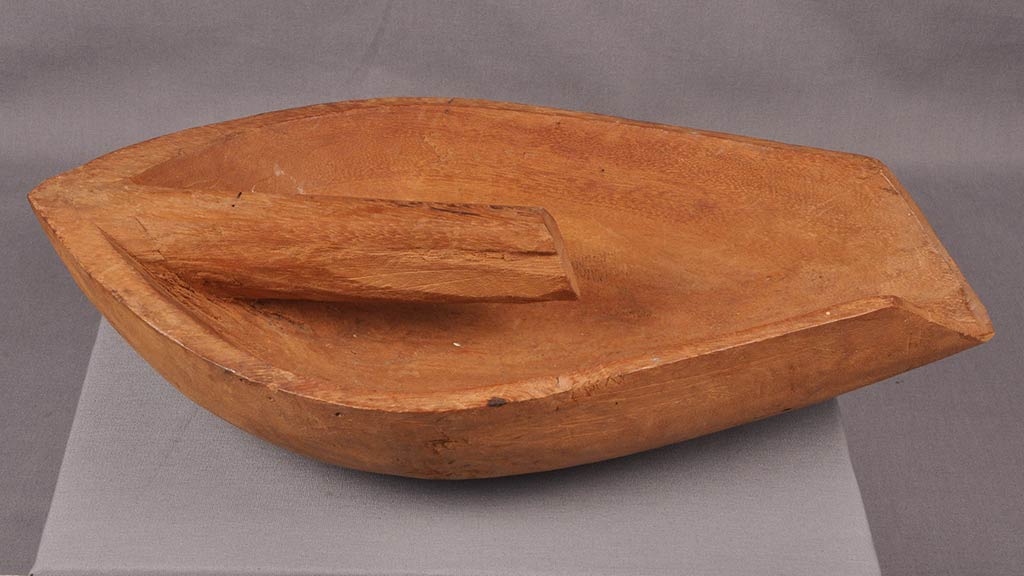 another wooden boat shaped object with a piece of wood going down the middle