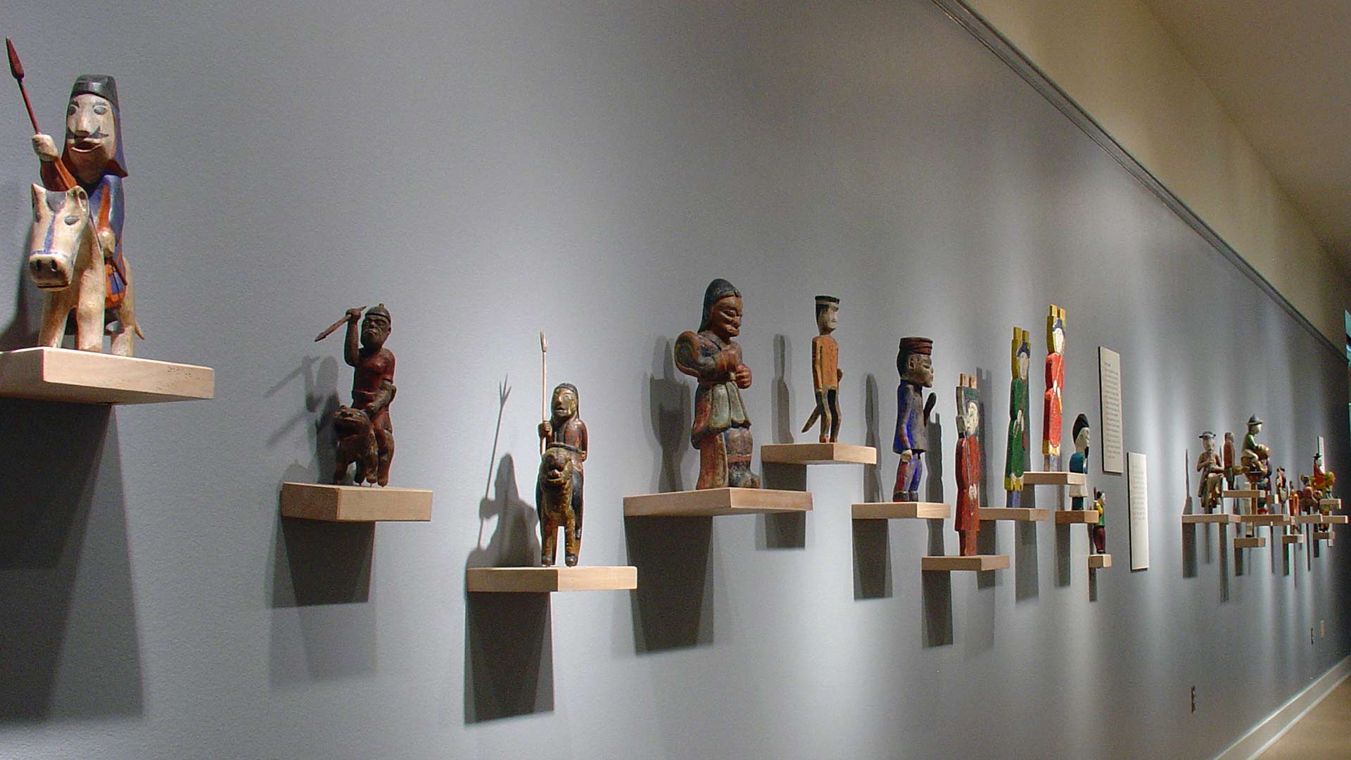 starting with a man on the horse back, figure sculptures arranged on the wall
