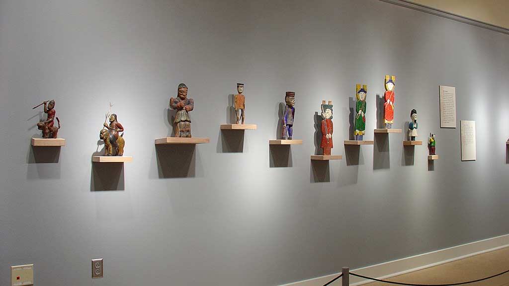 figure sculptures arranged on the wall from an angle