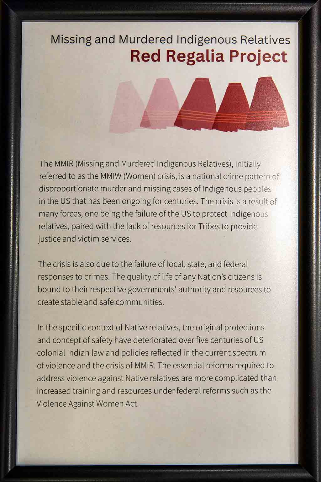 A black framed plaque discussing the history of Missing and Murdered Indigenous Relatives and the Red Reglaia Project