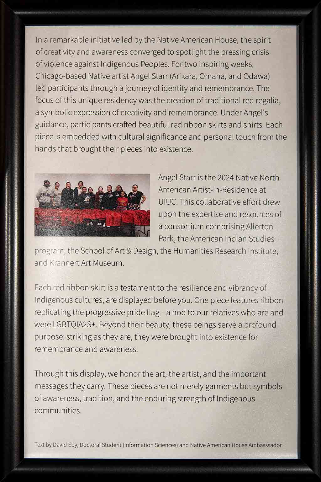 A black framed plaque discussing the history of Missing and Murdered Indigenous Relatives and the Red Reglaia Project