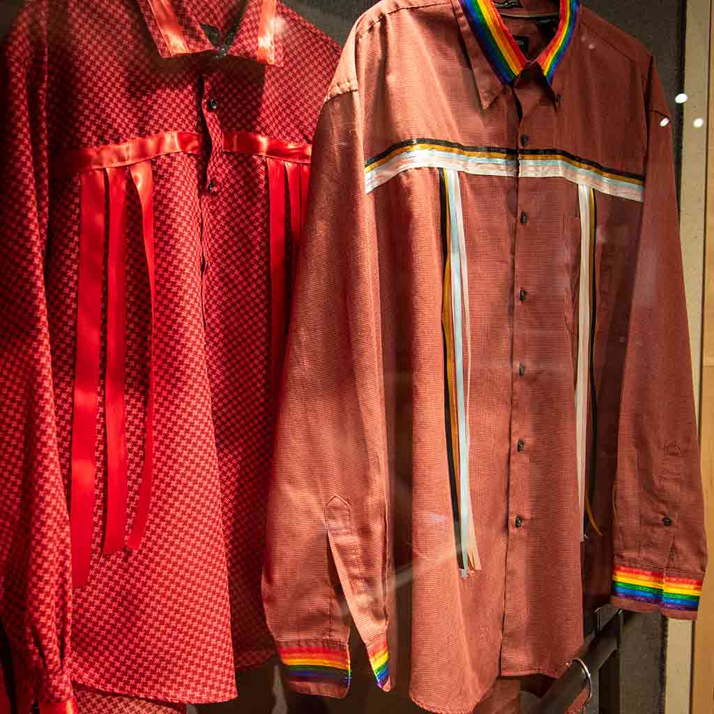 A red shirt with red ribbon and a brown shirt with its ribbon replicating the pride flag