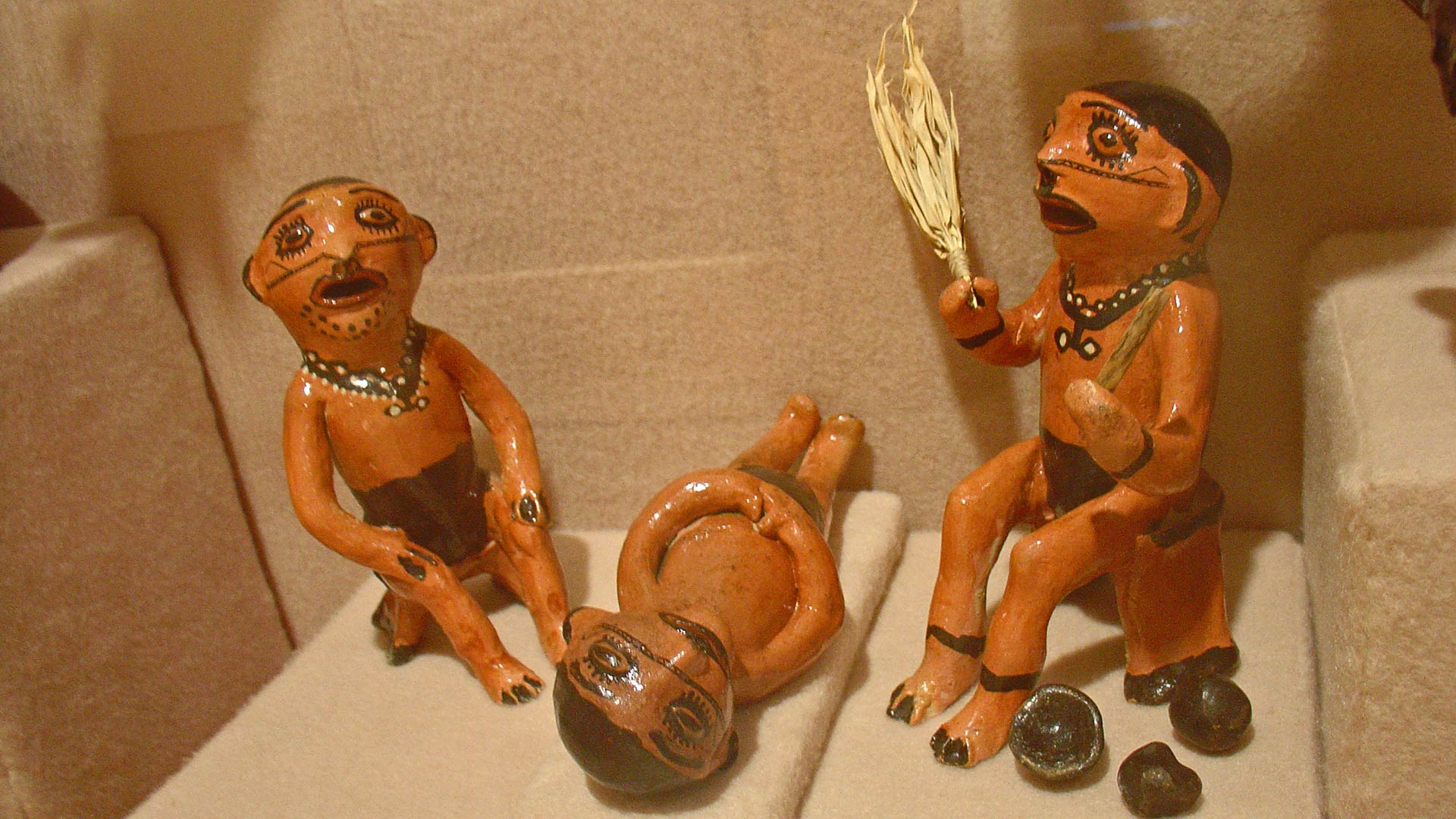 figures made of ceramic, two sitting, one lying on the floor