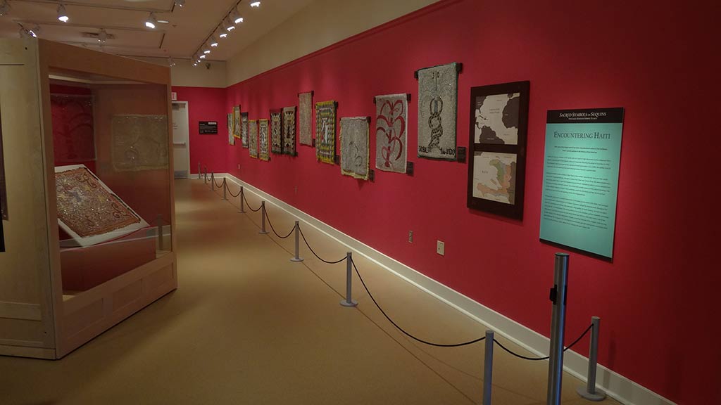 different vodou flags hung on the gallery wall