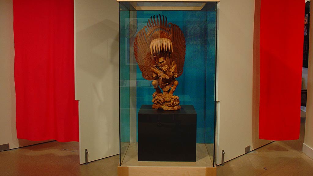 backdrop with red and ocean blue strips, wooden sculpture of a dwarf