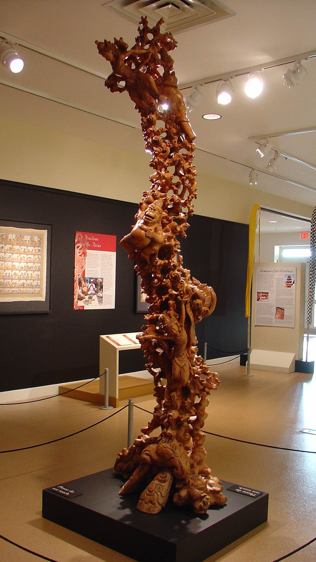 gallery view and wooden figues intertwined to form an elongated sculpture