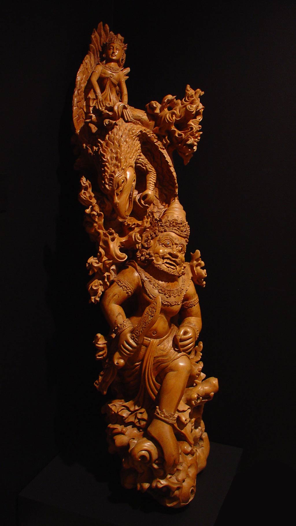 wooden figues intertwined to form an elongated sculpture