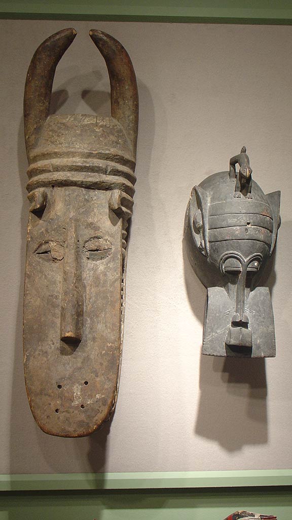 two wooden masks, one long and tall and the other short