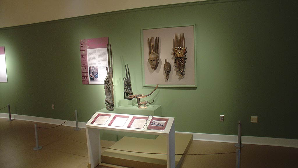 gallery view with wooden masks on a wall and artifacts on display